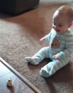 Cute_baby_laughs_at_flipping_toy.png